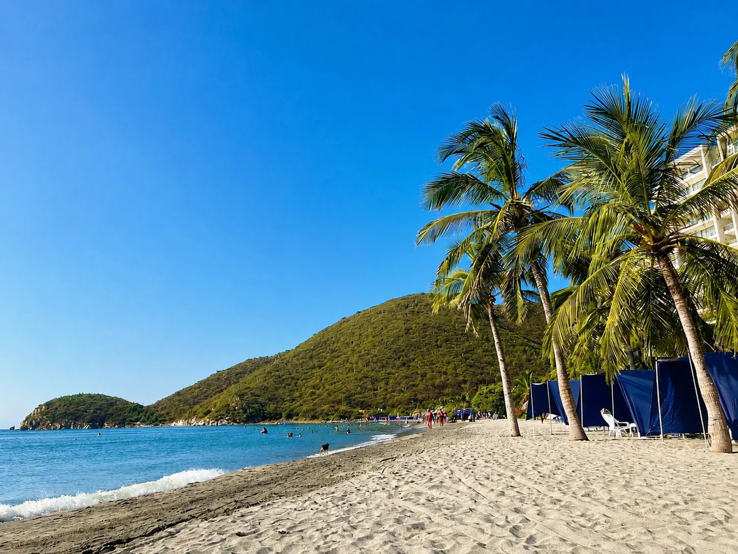 Playa Cabo Tortuga Santa Marta con carpas, arena amplia y montaña al fondo